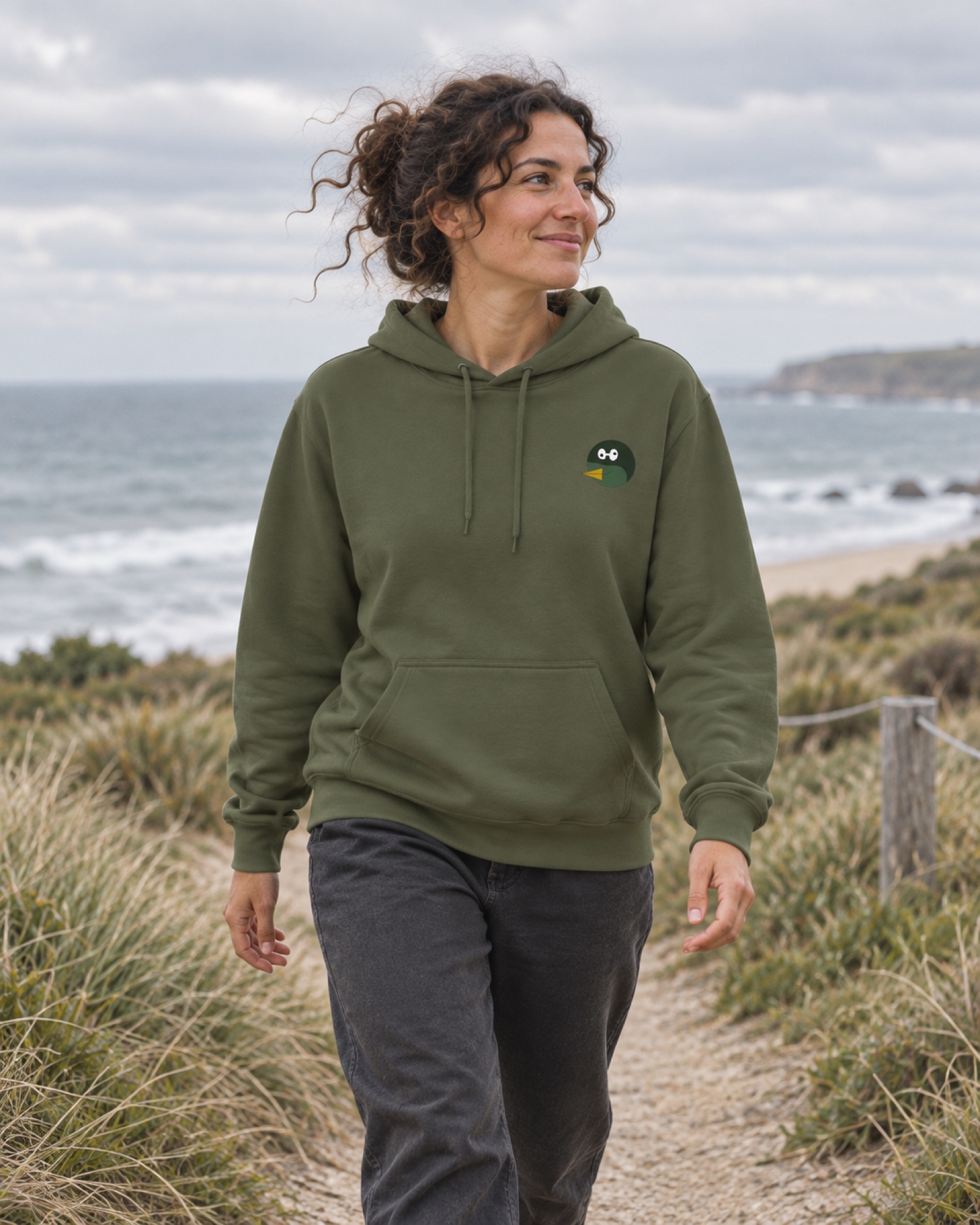 Generated campaign concept: an adult in a green Duckiepoos hoodie on a coastal walk